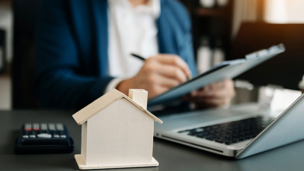 Couple européen consultant des documents immobiliers sur tablette dans un salon lumineux